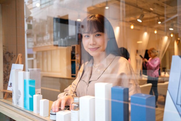 Frau macht das Schaufenster eines japanischen Friseurs fertig