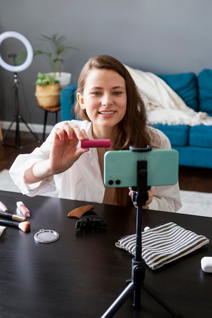 Kostenloses Foto frau macht einen make-up-vlog mit ihrem smartphone