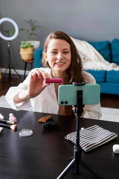 Frau macht einen Make-up-Vlog mit ihrem Smartphone