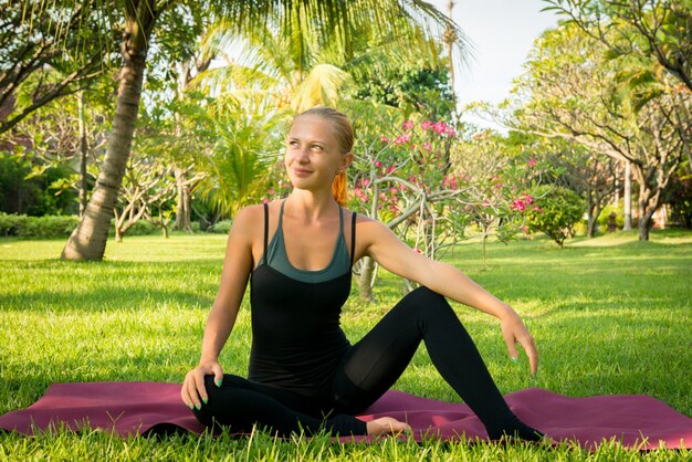 Frau macht Yoga im Garten