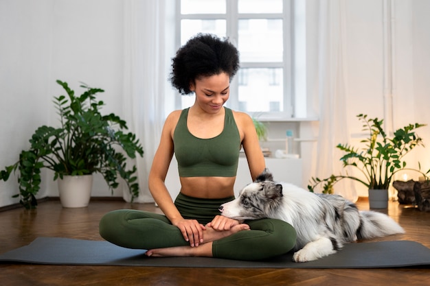 Frau macht Yoga in Begleitung ihres Haustieres