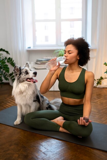 Kostenloses Foto frau macht yoga in begleitung ihres haustieres