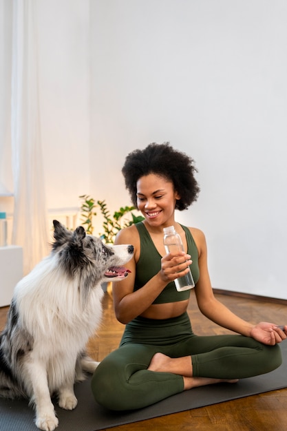 Frau macht Yoga in Begleitung ihres Haustieres