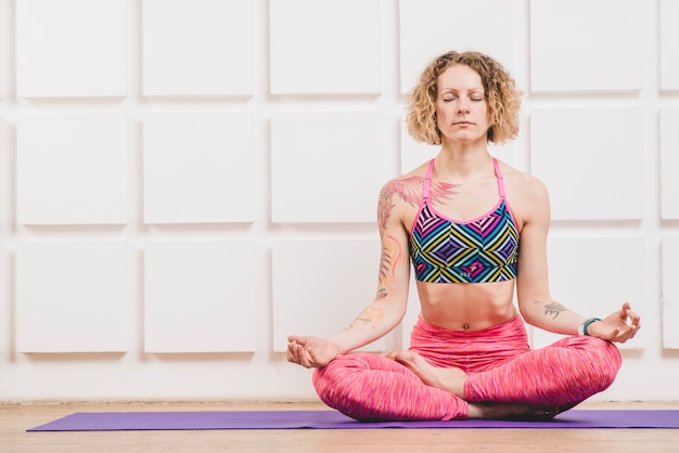 Kostenloses Foto frau meditiert in lotus asana zu hause