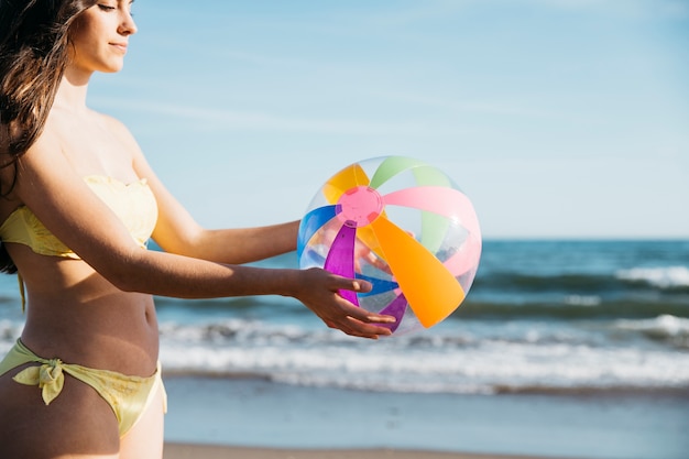 Frau mit aufblasbarem Ball am Strand