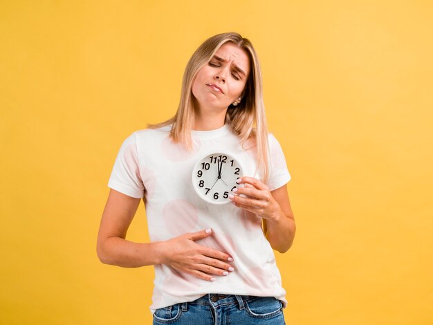 Frau mit Bauchschmerzen und Uhr