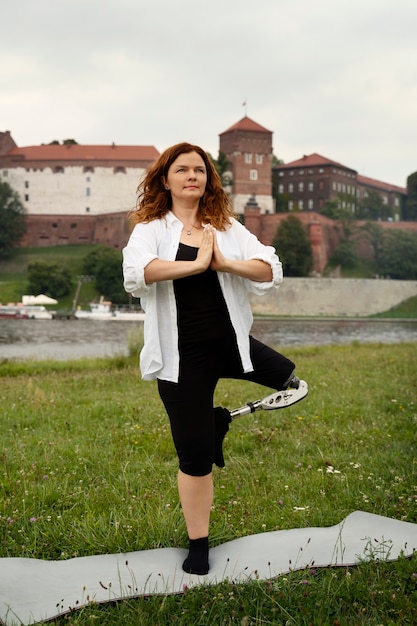 Frau mit Beinprothese beim Yoga