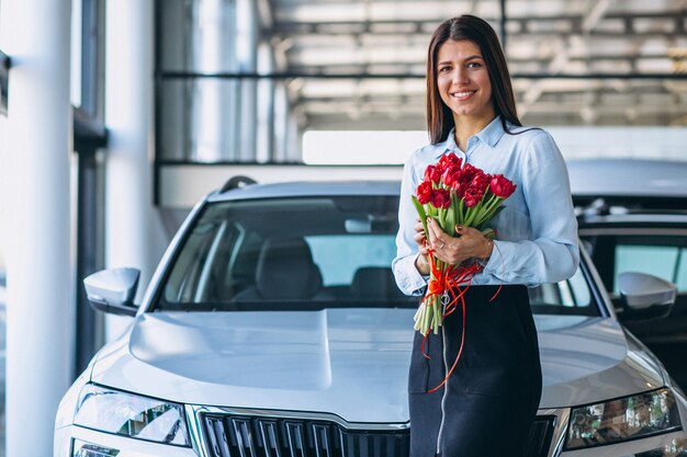 Frau mit Blumen in einem Autosalon