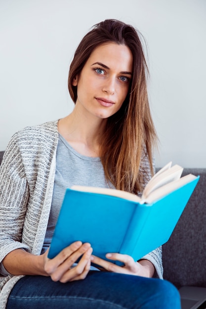 Frau mit Buch auf Sofa