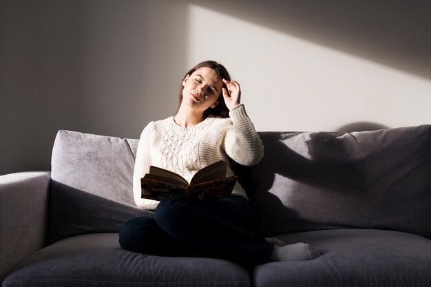 Frau mit Buch mit Augen geschlossen