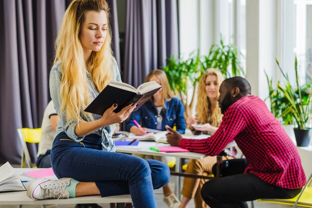 Frau mit Buch und Klassenkameraden