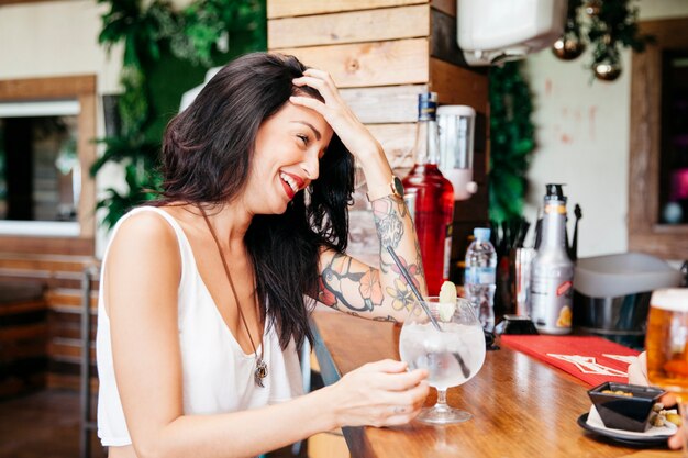 Frau mit Cocktail an der Bar