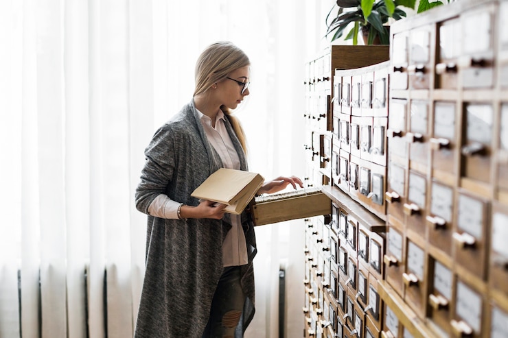 Kostenlose Foto frau mit dem buch, das nach karte im katalog sucht