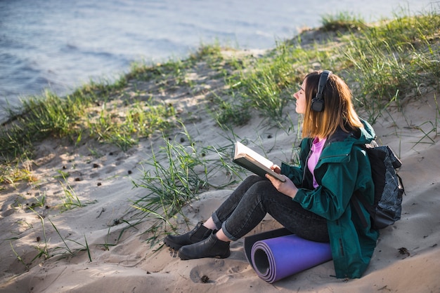 Kostenloses Foto frau mit dem buch musik genießend