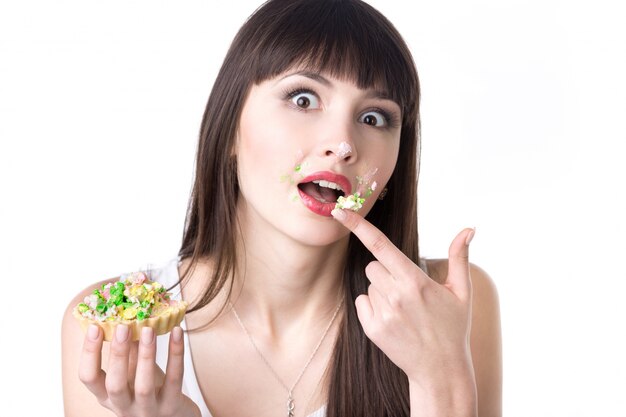 Frau mit dem Finger voll ein Kuchen