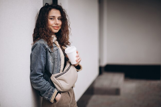 Frau mit dem lockigen Haar, das Kaffee trinkt