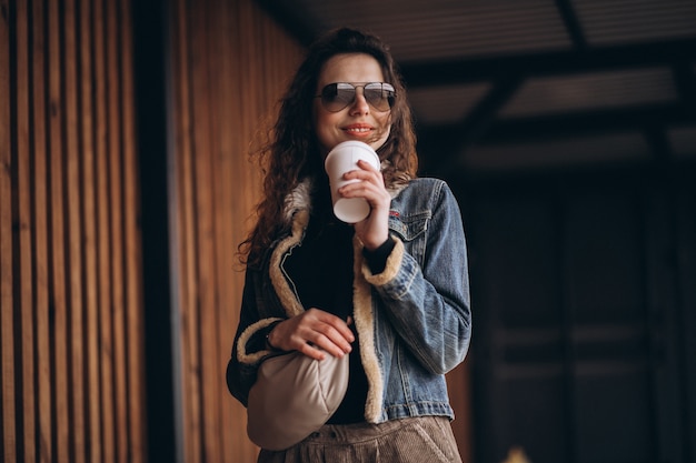 Frau mit dem lockigen Haar, das Kaffee trinkt