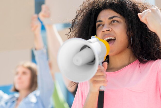 Frau mit dem lockigen Haar, das niedrige Ansicht protestiert