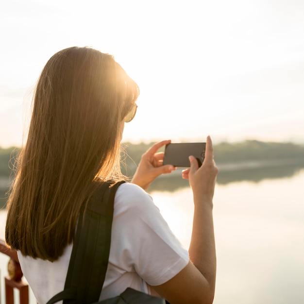 Frau mit dem Smartphone, das die Ansicht während des Reisens fotografiert