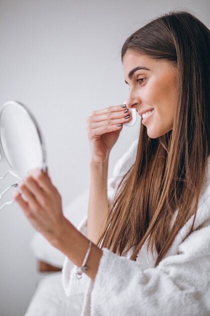 Frau mit dem Spiegel, der Make-up mit Auflage entfernt