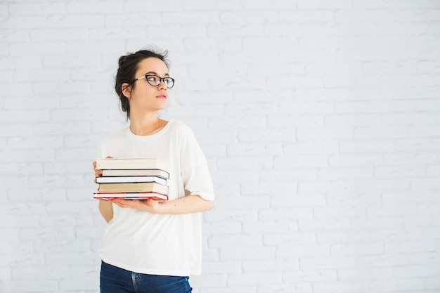 Frau mit dem Stapel Büchern, die weg schauen