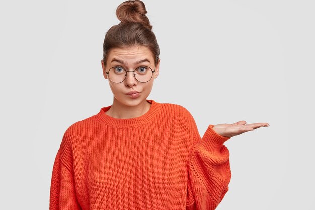 Frau mit den Haaren in einem Brötchen, das übergroßen Pullover trägt