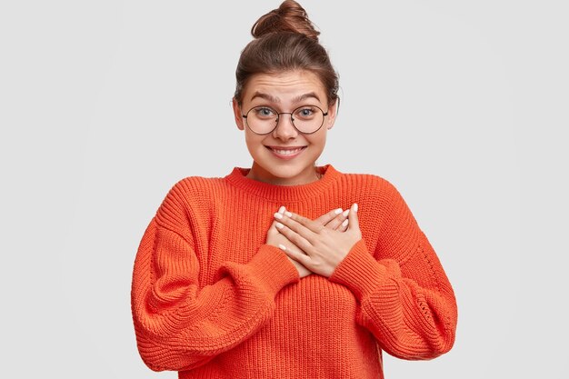 Frau mit den Haaren in einem Brötchen, das übergroßen Pullover trägt