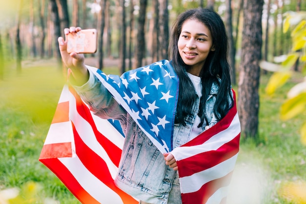 Frau mit der Flagge, die selfie nimmt