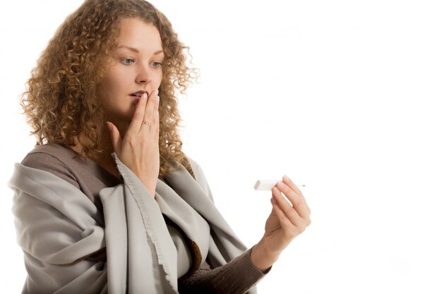 Frau mit der Hand in den Mund Blick auf Thermometer