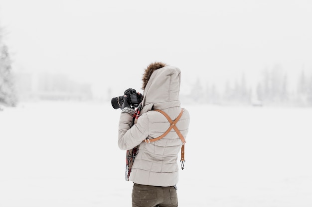 Frau mit der Kamera, die im Winter steht