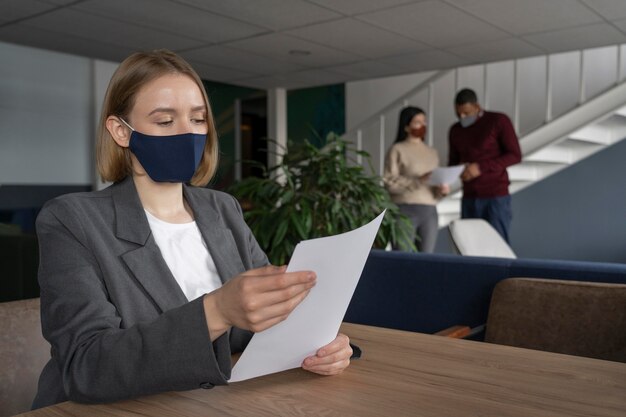 Frau mit der medizinischen Maske, die arbeitet