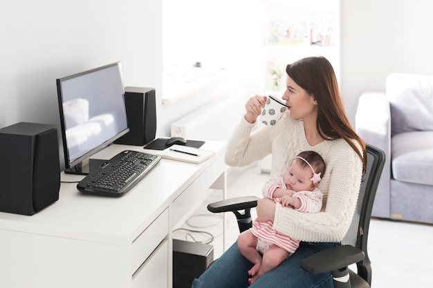 Frau mit der Schale, die Tochter am Computer hält