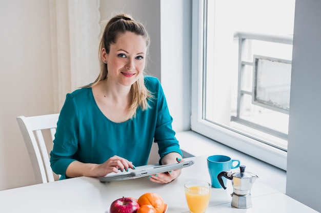 Frau mit der Tablette, die Kamera betrachtet