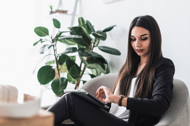 Frau mit der Tablette, die Uhr betrachtet