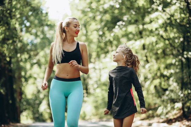 Frau mit der Tochter, die im Park rüttelt