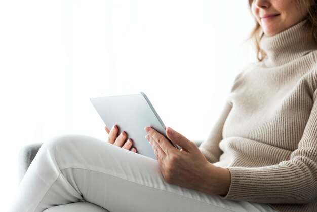 Frau mit digitalem Tablet auf einer Couch