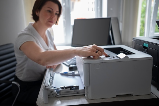 Kostenloses Foto frau mit drucker im büro