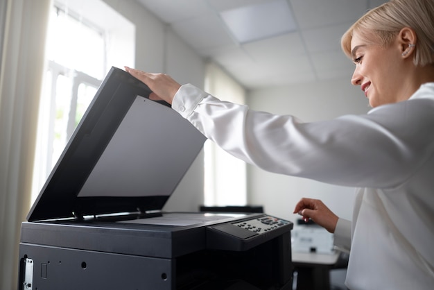 Kostenloses Foto frau mit drucker während der arbeit im büro