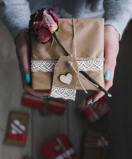 Frau mit einem Geschenk und einer trockenen Rose