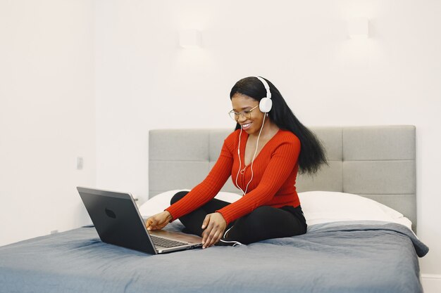 Frau mit einem Laptop auf dem Bett