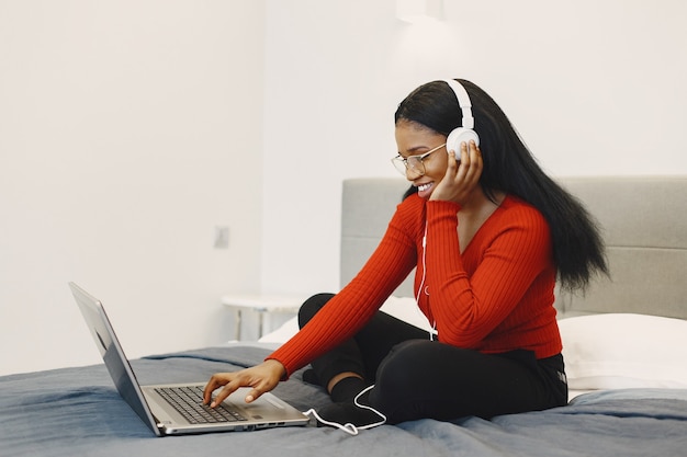 Frau mit einem Laptop auf dem Bett