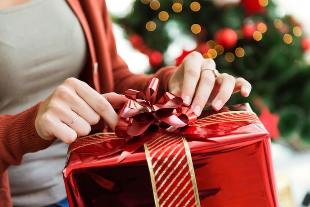 Frau mit einem roten Geschenk öffnen