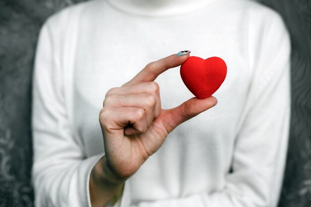 Frau mit einem roten Herz in der Hand