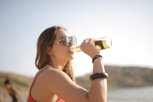 Frau mit einer Flasche Getränk mit Zubehör