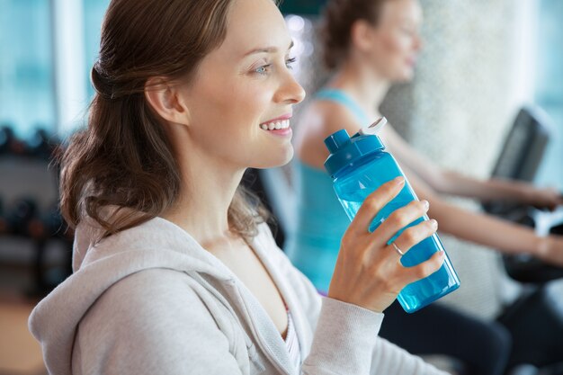 Frau mit einer Flasche Wasser lächelnd