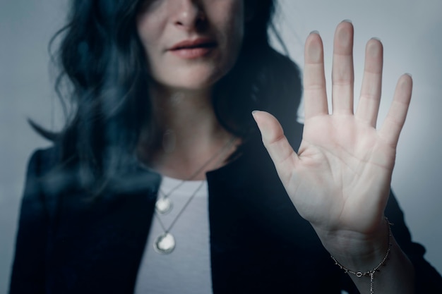 Frau mit einer schönen Hand, die das Fenster berührt