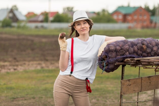 Frau mit einer Tasche von Früchten auf einem Bauernhof