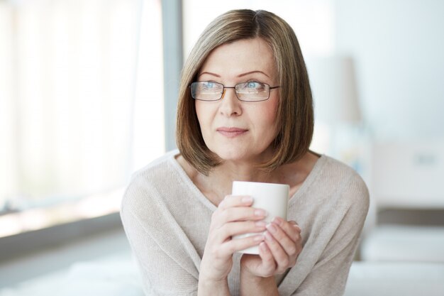 Frau mit einer Tasse Tee zu denken