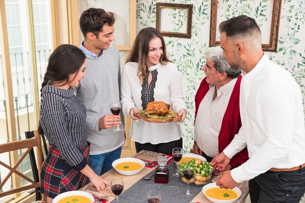 Frau mit gebackenem Huhn am festlichen Tisch