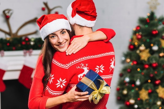 Kostenloses Foto frau mit geschenk umarmen mann